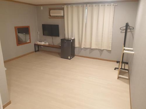 a living room with a large room with a television and a desk at Seorak HOT Spring Mammoth Resotel in Sokcho