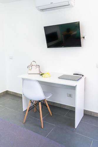 a white desk with a computer monitor and a chair at Hotel & Spa Relais Freedom Club in Massa Lubrense