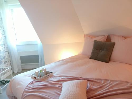 a bedroom with a large white bed with pink pillows at Les chambres du Vert Galant "La campagne qui murmure" in Verlinghem