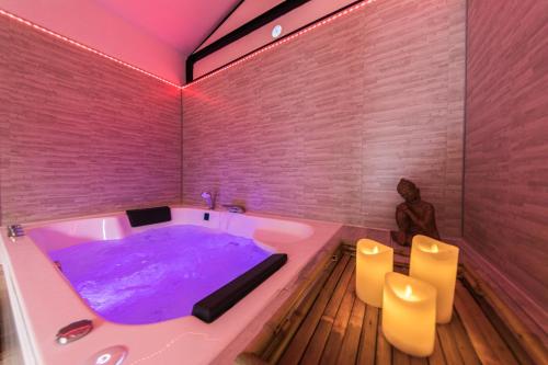 Un baño con una bañera con agua morada. en Zen & Spa - Maison Cosy - Tours - Netflix, en Tours