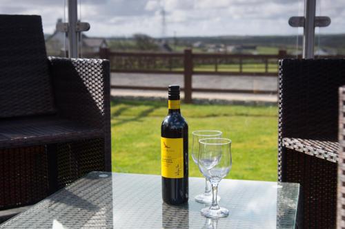 a bottle of wine sitting on a table with a glass at The Lodge in Amlwch