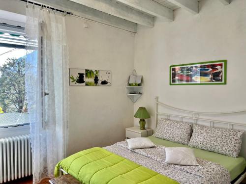 a bedroom with a green bed and a window at B&B By Lussy - Camera Verde in Menaggio