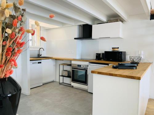 a kitchen with white appliances and a vase with flowers at Magnifique duplex vue mer inoubliable Sanary Sur Mer in Sanary-sur-Mer