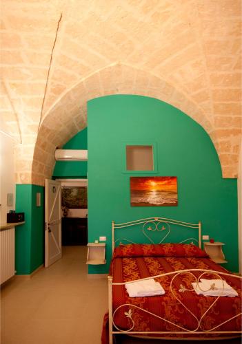 a bedroom with a bed with a green wall at Le Pentume in Arnesano