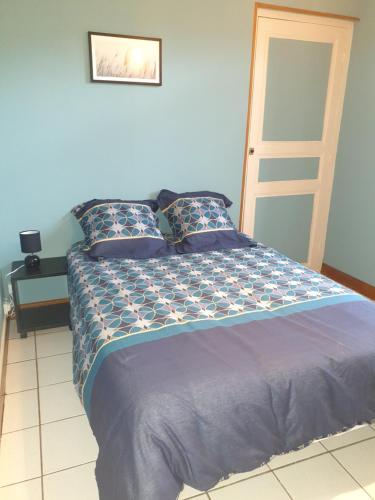 Schlafzimmer mit einem Bett mit blauer Bettwäsche und einer Leiter in der Unterkunft LE RELAX in Lurcy-Lévis