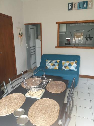 eine Küche mit einem Tisch und einem blauen Sofa in der Unterkunft LE RELAX in Lurcy-Lévis