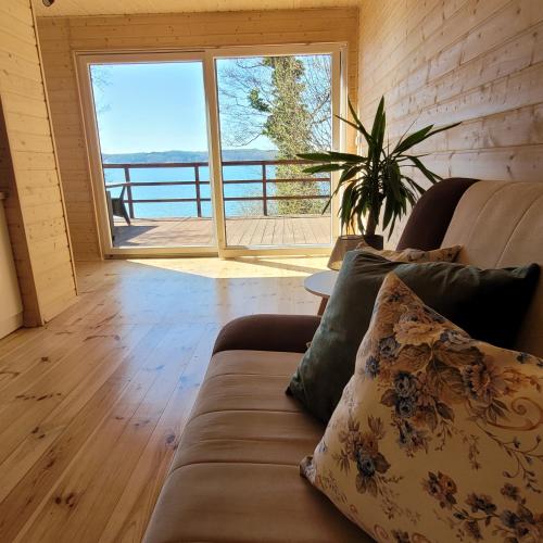 a living room with a couch and a large window at Domek Lubkowo z widokiem in Lubkowo