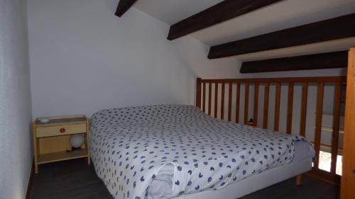 a small bedroom with a bed and a night stand at Pavillon T2 Mezzanine, Les Frégates, St Pierre la Mer in Saint Pierre La Mer