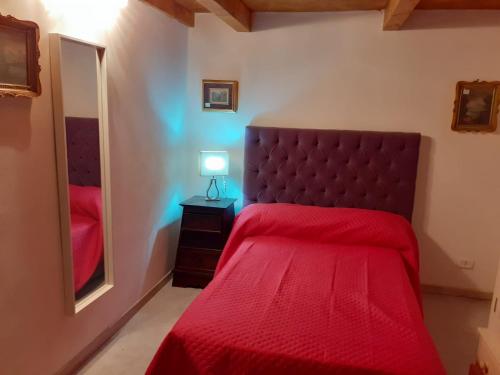 Schlafzimmer mit einem roten Bett und einem Spiegel in der Unterkunft Domvs 84 in Torre Annunziata