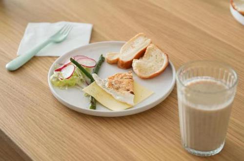 a plate of food on a table with a glass of milk at Blue Sea Hotel in Dali