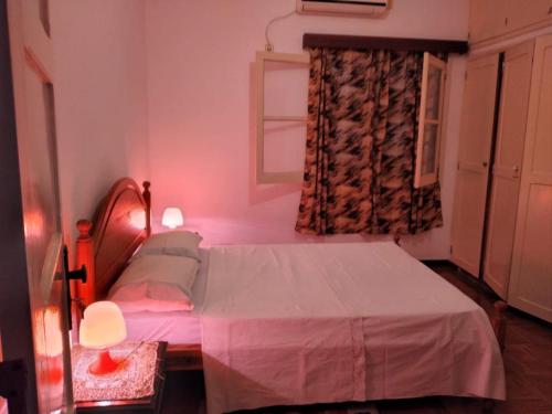 a small bedroom with a bed and a window at Santos`s House in São Tomé