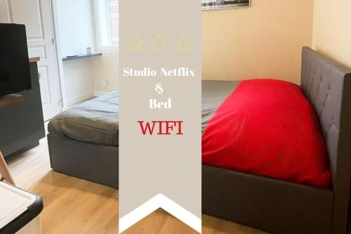 une chambre avec un lit avec un oreiller rouge et un ordinateur portable dans l'établissement Studio Netflix & Bed, à Amiens