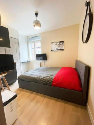 une chambre avec un lit et une horloge au mur dans l'établissement Studio Netflix & Bed, à Amiens