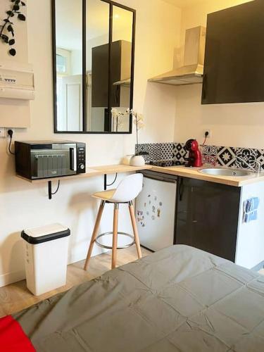une cuisine avec un comptoir, un micro-ondes et un tabouret dans l'établissement Studio Netflix & Bed, à Amiens
