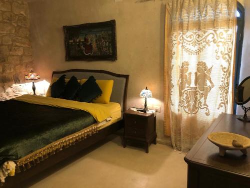 a bedroom with a bed and a table with two lamps at Chateau du Roi in Mi‘ilyā