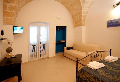 a room with a bed and a couch and a window at Le Pentume in Arnesano