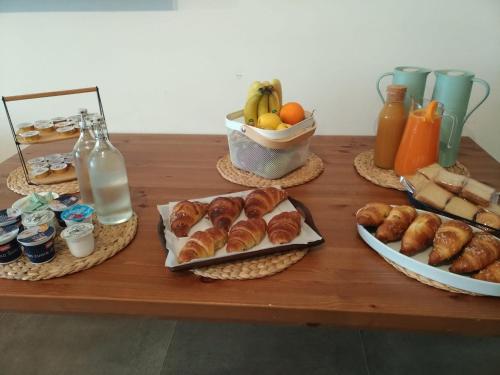 una mesa con cruasanes y otros alimentos para el desayuno. en Verde Matematico en Vico del Gargano