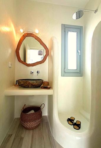 a bathroom with a sink and a mirror at Beach Apartment Thalia with Hot Tub and Sea View in Agios Prokopios