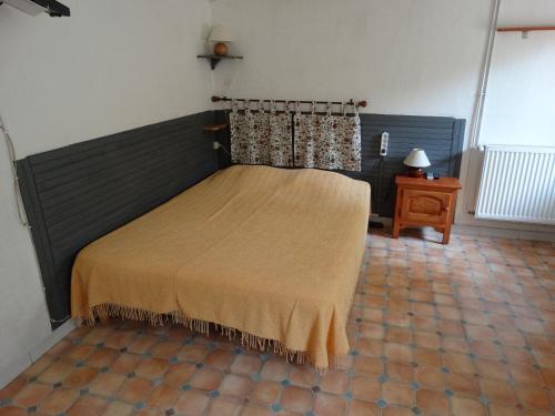 - une chambre avec un lit doté d'une couverture brune dans l'établissement Le Claux des Hespérides, à Allemagne-en-Provence