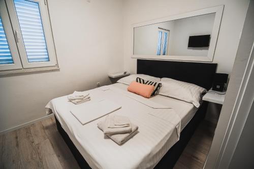 a bedroom with a white bed with towels on it at Downtown Park Apartments with Balcony in Vodice