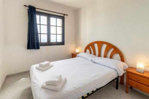 1 dormitorio con 1 cama con 2 toallas en Cau del Llop 76 apartamento piscina comunitaria en Girona