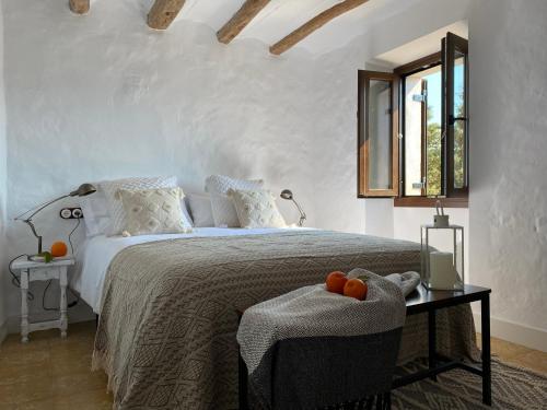 Un dormitorio con una cama y una mesa con naranjas. en Casa rural con jardín,a 8km playa y en la naturaleza Taronja&canyella, en Ardenya