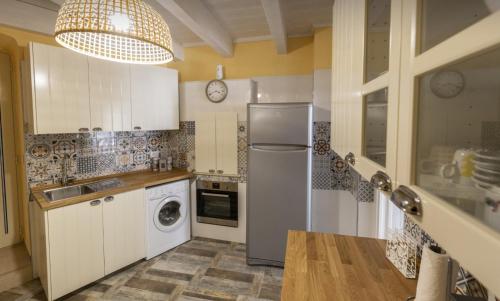 Una cocina con gabinetes blancos y un refrigerador. en Natiolum la casa vacanze a Giovinazzo, en Giovinazzo