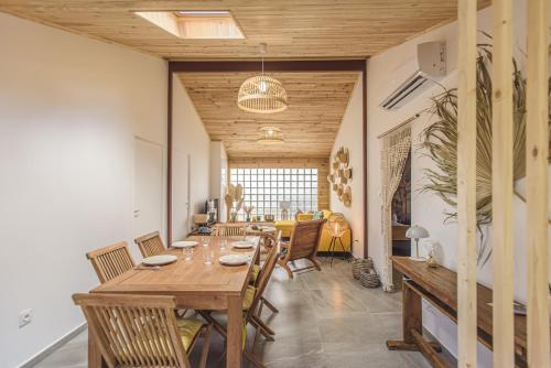 a dining room with a wooden table and chairs at Ti Kaz Lontan - La Rivière in Saint-Louis