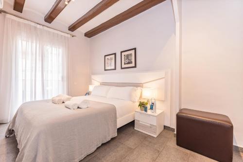 Un dormitorio blanco con una cama blanca y una ventana en Sweet Inn - Villarroel, en Barcelona