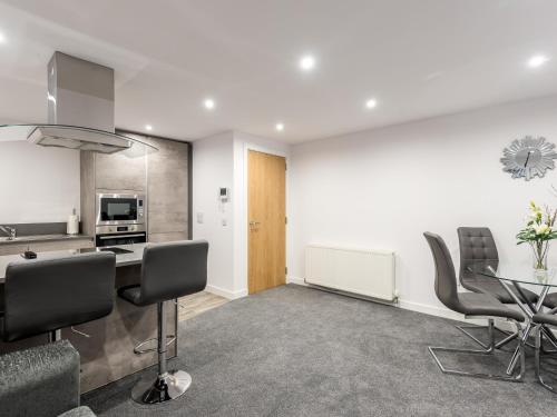 a kitchen and living room with a table and chairs at Casa Fresa - Castle Heights Apartment in Dundee