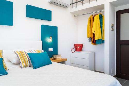 a bedroom with a white bed with blue accents at Hotel & Spa Relais Freedom Club in Massa Lubrense