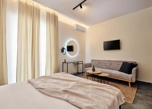 a bedroom with a bed and a couch at Amaroo Suites in Laganas
