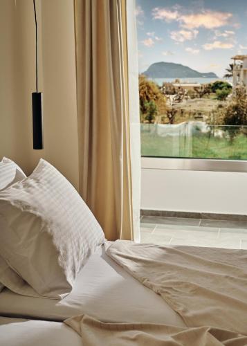 un letto con una finestra con vista sulla città di Amaroo Suites - 250m from the beach, by ZanteWize a Laganas