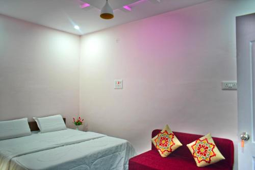 B R Inn في بانغالور: غرفة نوم بسرير وكرسي احمر