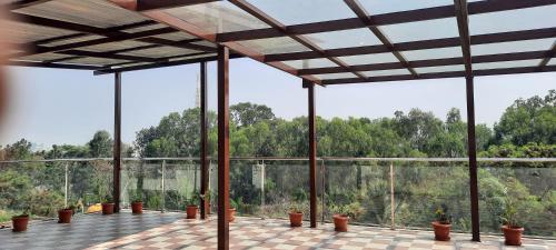 a large room with potted plants and windows at B R Inn in Bangalore