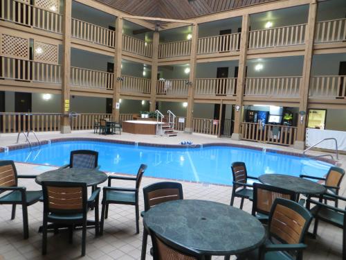 a large pool with tables and chairs in a hotel at Super 8 by Wyndham Spearfish in Spearfish