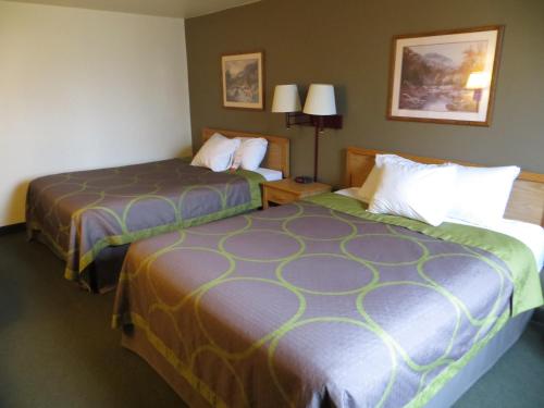 a hotel room with two beds next to each other at Super 8 by Wyndham Spearfish in Spearfish