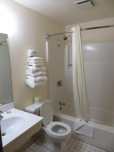 a bathroom with a toilet and a sink and a shower at Super 8 by Wyndham Spearfish in Spearfish