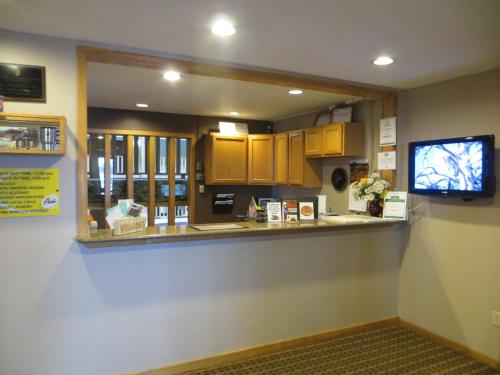 a kitchen with a counter with a tv in it at Super 8 by Wyndham Spearfish in Spearfish
