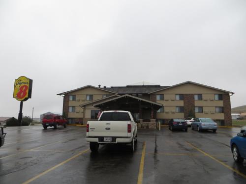 a white truck parked in a parking lot in front of a building at Super 8 by Wyndham Spearfish in Spearfish