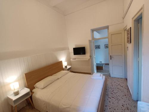 ein Schlafzimmer mit einem großen Bett mit 2 Tischen und einem TV in der Unterkunft Sea Side Villa in Mondello