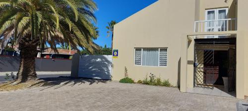 a palm tree next to a building with a garage at Shalom Self catering in Cape Town