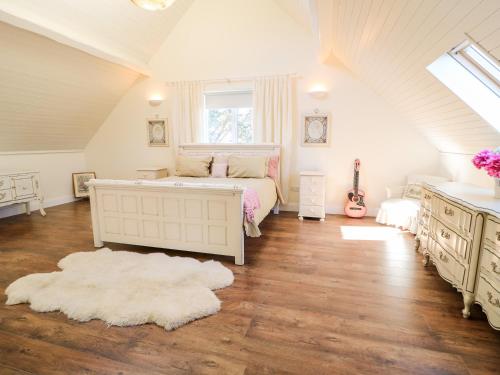 a attic bedroom with a bed and a window at Wisteria Cottage in Annagry