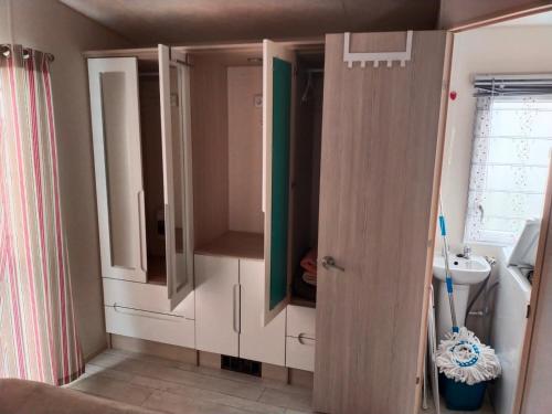 a bathroom with white cabinets and a sink at MOBIL HOME LE MAGNIFIQUE VALRAS PLAGE in Valras-Plage