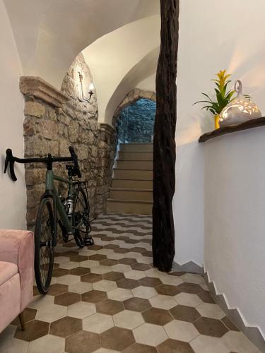 una bicicleta estacionada en una habitación con una pared de piedra en Regnos Altos boutique rooms en Bosa