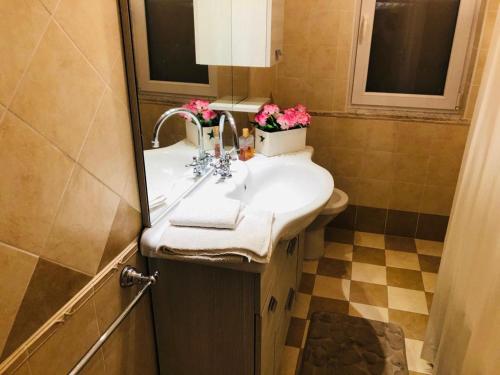 ein Badezimmer mit einem Waschbecken mit Blumen darauf in der Unterkunft Casa Anna in Maiori