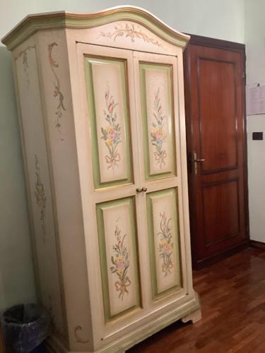 a large cabinet with paintings on it next to a door at Hotel Savona in Montecatini Terme