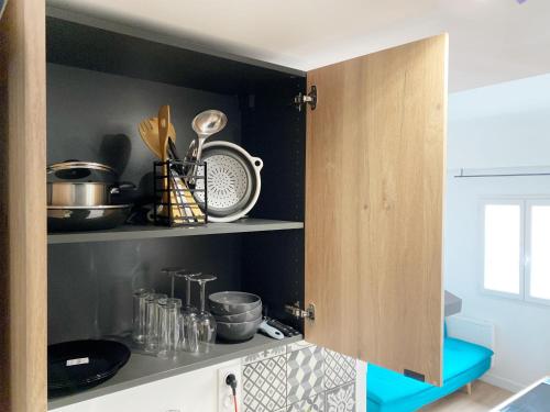 - une cuisine avec des murs noirs et des étagères avec des ustensiles dans l'établissement HYPERCENTRE 3 appartement climatisé, à Toulouse