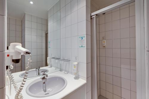 a bathroom with a sink and a blow dryer at Hotel am Südtor in Backnang