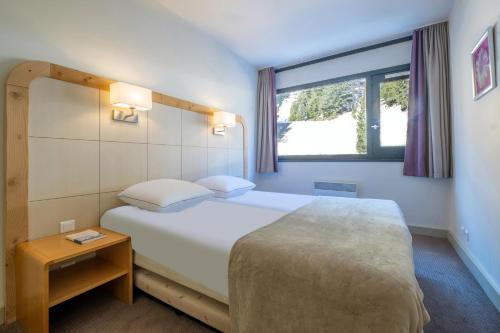 a hotel room with a bed and a window at Résidence Pierre & Vacances La Forêt in Flaine